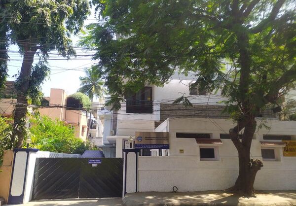 Foto de la entrada principal de Hosokawa Micron India PVT LTD, un edificio blanco rodeado de grandes árboles
