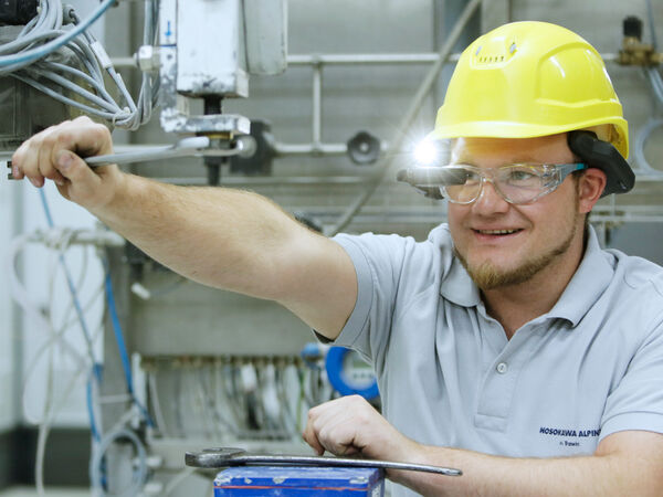 Un empleado de Hosokawa Alpine realizando mantenimiento en una máquina.