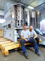 Dos hombres sentados delante de una máquina Polyplex